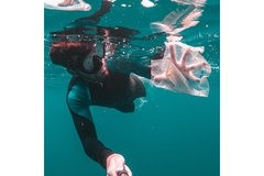 Image Scooba diver collecting plastic in the ocean.
